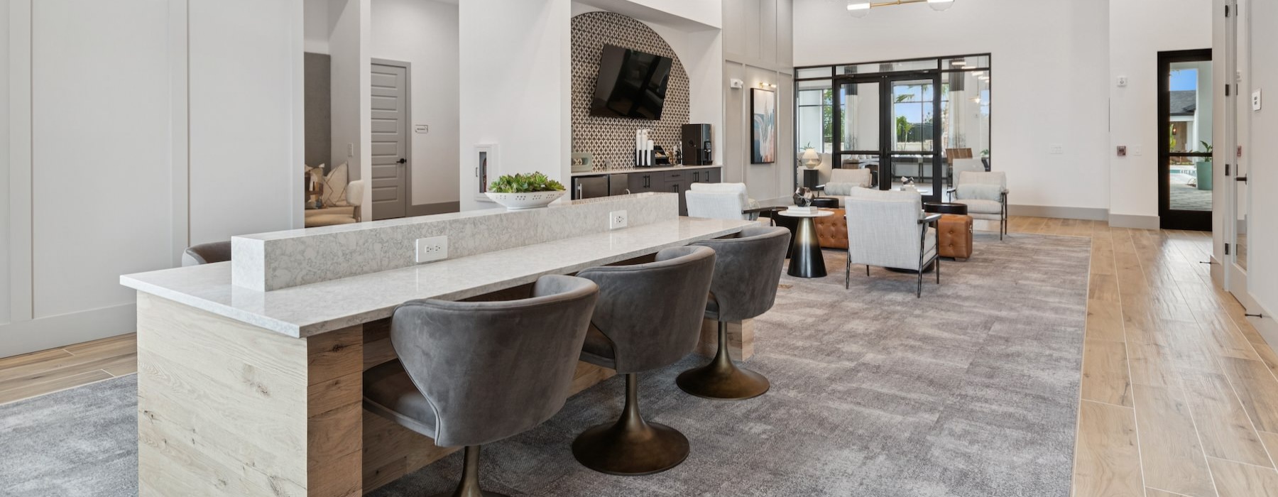 a clubroom with a kitchen, a bar and chairs