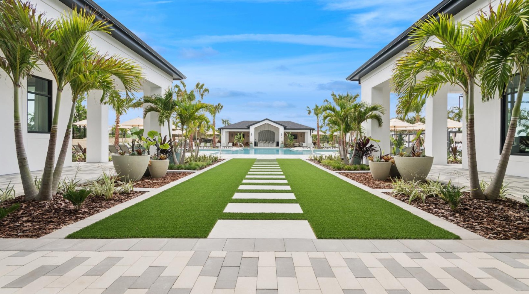 a courtyard with palm trees and a stone path